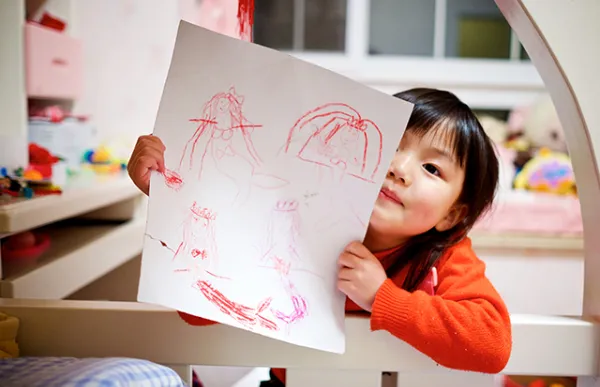 child holding up drawing