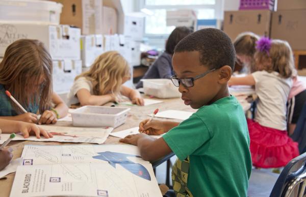 Young students work at desks in a classroom