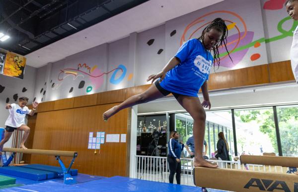 Girl stands on balance beam