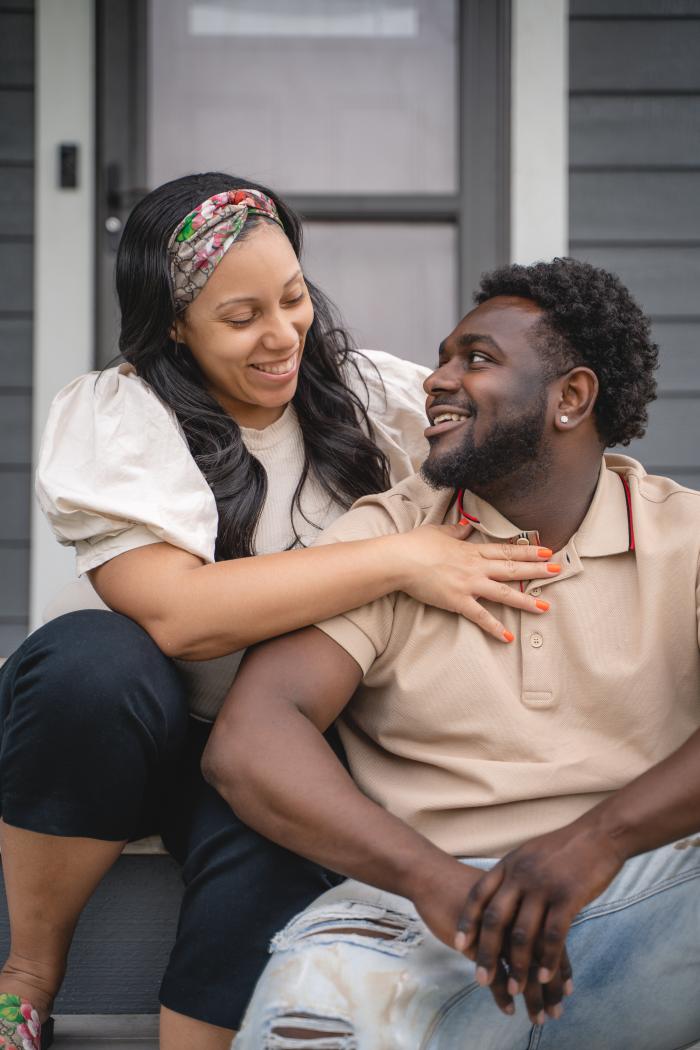 Briana and Key look into each other's eyes on the front porch.