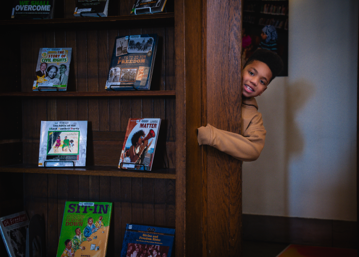 Shai peeking his head around a corner of the book nook