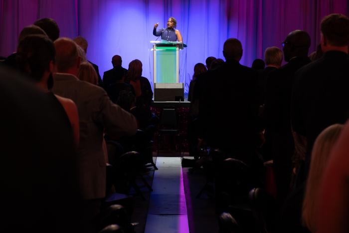 A woman stands at a podium