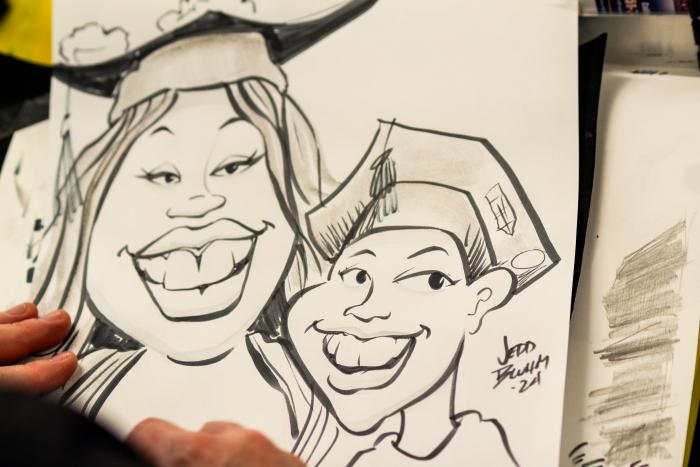 A caricature of a woman and boy wearing graduation caps.