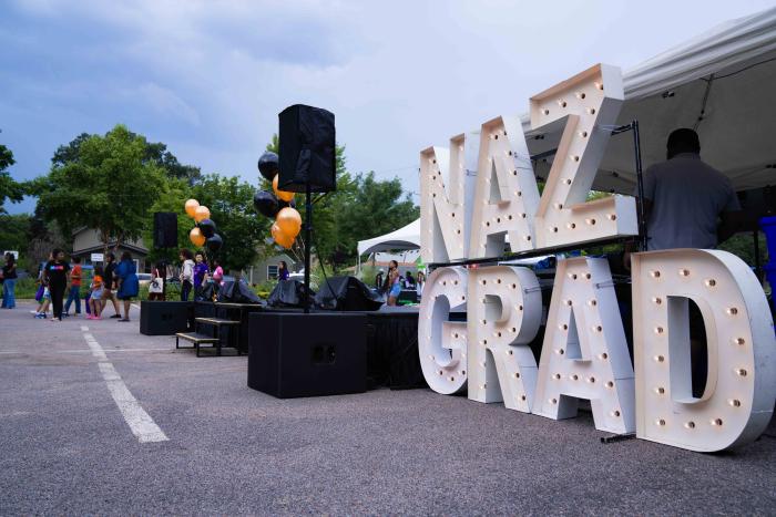 a stage and large light up letters reading "NAZ Grad"