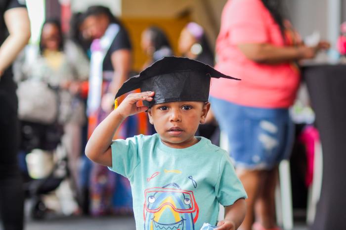 Small child wearing a graduation cap